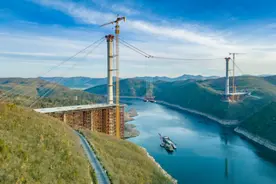 国内最大跨峡谷斜拉桥首节钢箱梁吊装成功图片