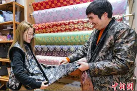 （新春走基层）皮革城里“吹新风” 浙江海宁“新中式”过年服饰走俏图片