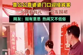 喜公公喜婆婆门口迎接宾客，一个跳着行礼 ，一个发围裙，网友：挺有意思  热闹又不低俗图片