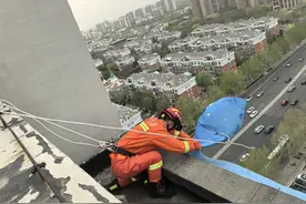 惊险！大风掀起防盗窗铁皮，消防员18楼顶边缘紧急排险图片