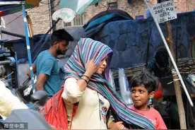 印度新德里热浪持续侵袭城市 民众戴头巾防晒图片