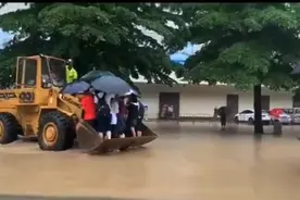广东廉江连降暴雨造成积水，警方用铲车护送考生到考场图片