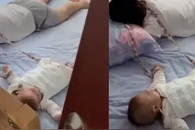机智！爸爸为防止宝宝翻下床 用裙带绑娃系脖子上睡觉图片