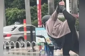 女子骑车在马路上“练瑜伽”：穿高跟鞋单脚站立 另一条腿抬至头顶图片