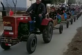 拖拉机被改造成观光小火车，载着大人小孩在村里游玩图片