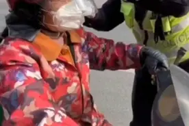 大妈戴头盔感觉哪里怪怪的，遇交警一把撕下保护膜图片