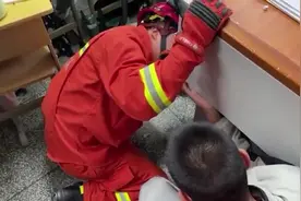 男生因上课无聊抠讲台手卡桌洞，消防破拆救出：想好咋检讨没图片
