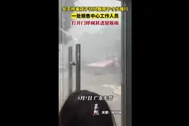 女子抱着孩子狂风暴雨中寸步难行，一处销售中心工作人员打开门呼喊其进屋躲雨图片