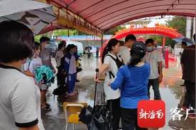 海南高考首日遇阴雨天气  三亚市第一中学考点为考生搭建简易雨棚图片