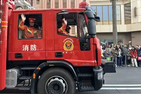 消防车领航北京环球度假区花车巡游，游客们竞相拍照留念图片