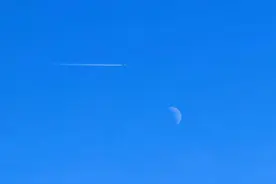 北京冬日奇景，临近晌午，淡淡的月亮挂在天空图片