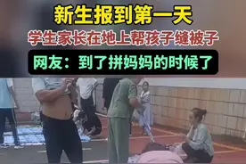 新生报到第一天，学生家长在地上帮孩子缝被子，网友：到了拼妈妈的时候了。图片