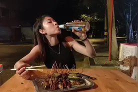 烧烤摊欢妹趁没有生意，自己喝啤酒吃烧烤，还说啤酒配烧烤真爽！