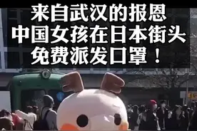 一华人身穿玩偶服抱着纸箱，在日本街头免费发放口罩。纸箱上写着：来自武汉的报恩♥️#正能量 #暖心 @抖音短视频